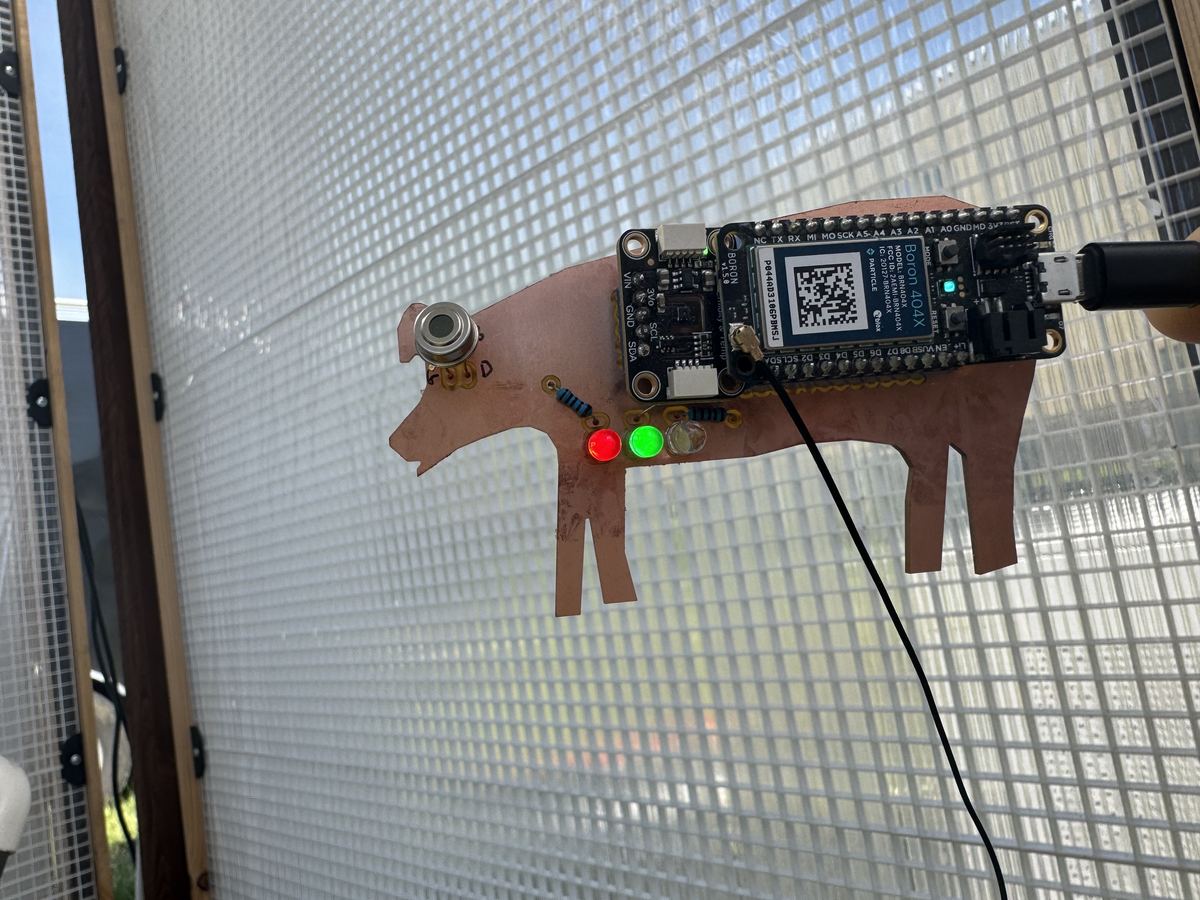 CoolSwine sensor prototype with IoT board mounted on pig cutout in barn panel